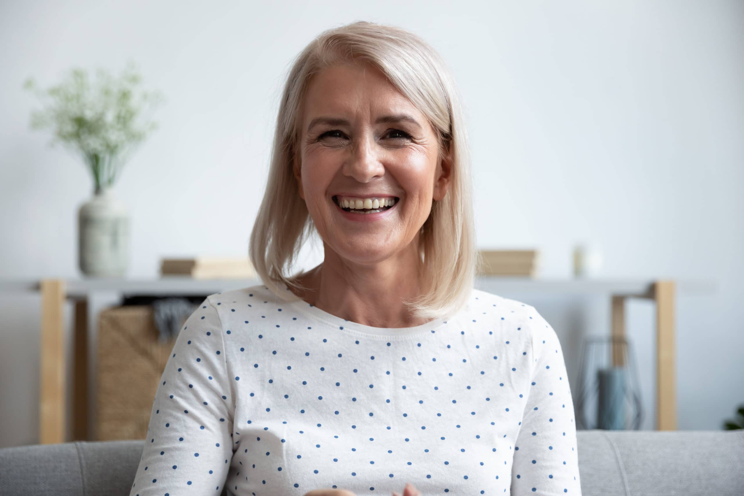 Happy,mature,old,woman,blogger,looking,at,camera,at,home,